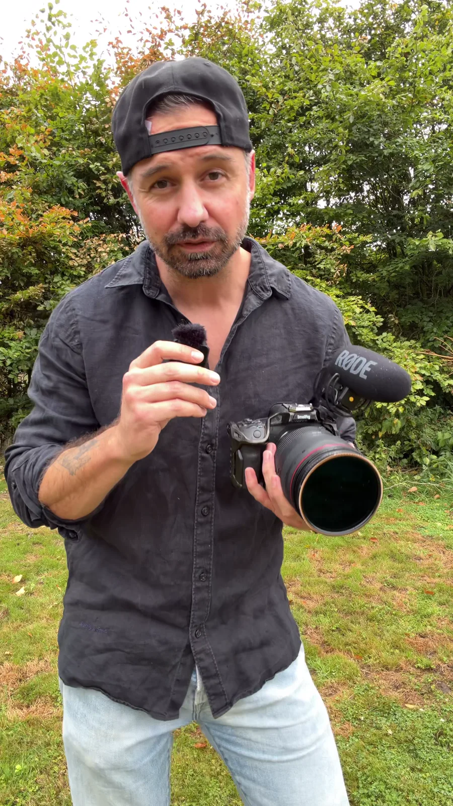 Roy houdt een camera met microfoon vast terwijl hij uitlegt dat fotografie en filmen gecombineerd kunnen worden