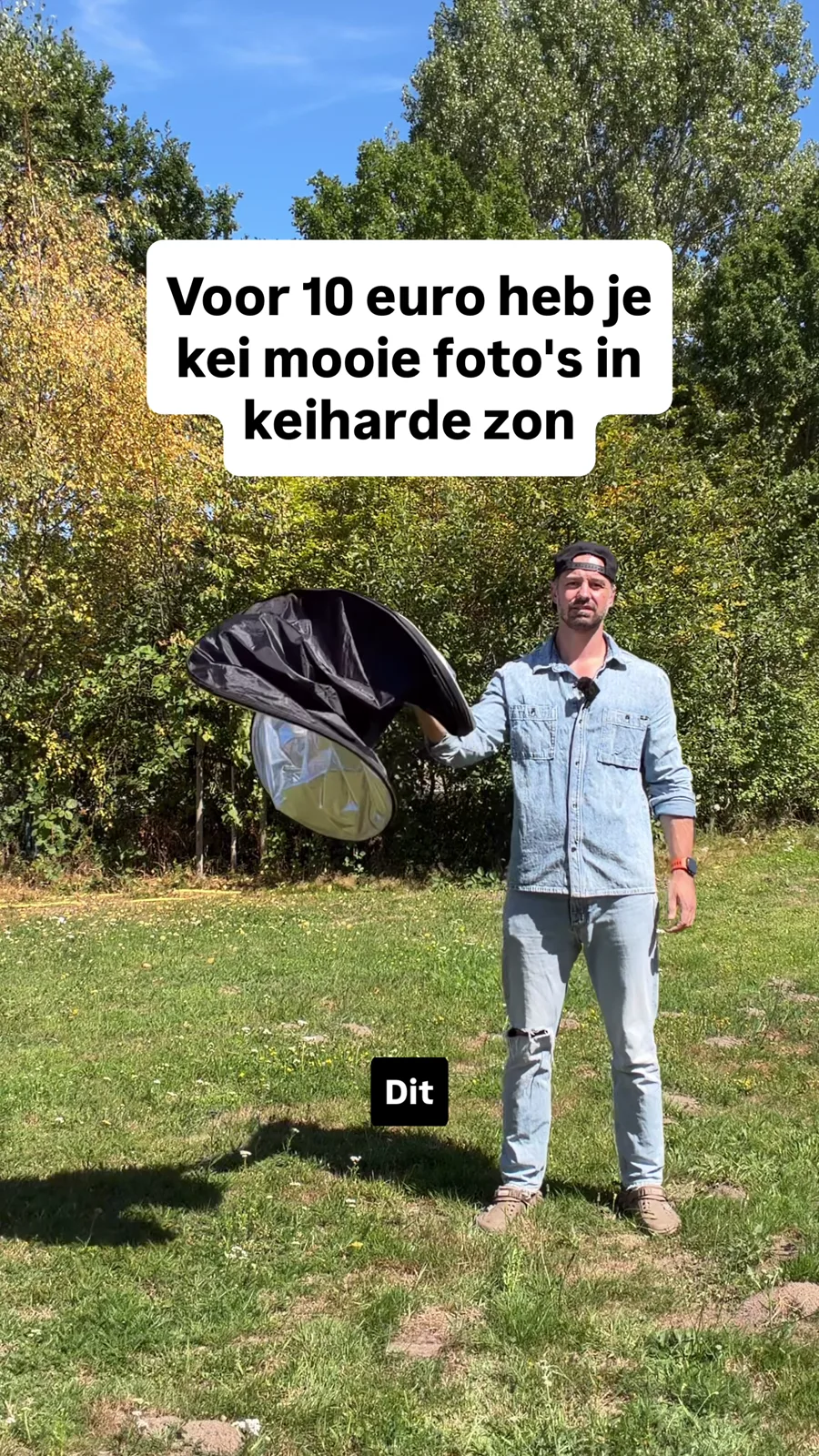 Roy staat in felle zon met een opvouwbaar reflectiescherm