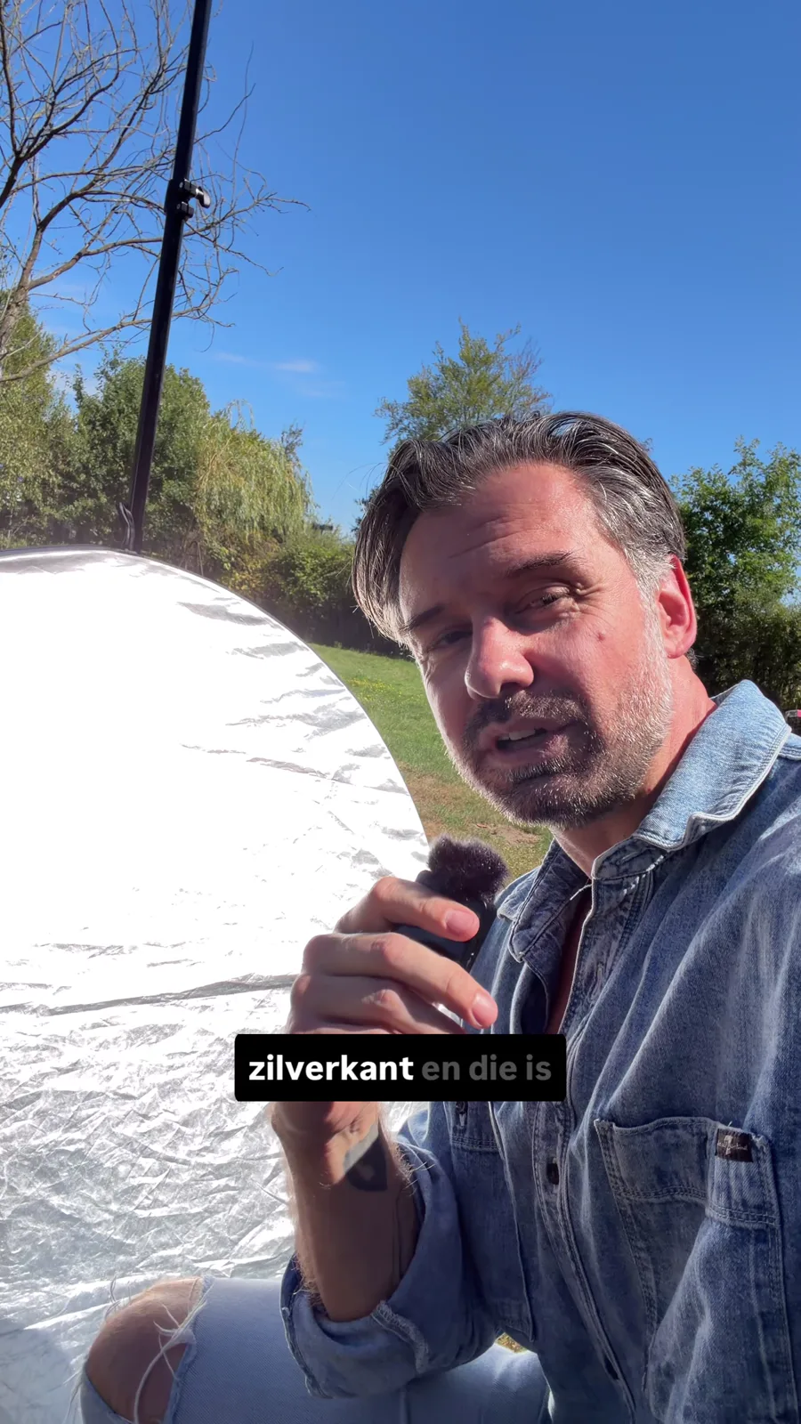 Roy toont de zilveren kant van zijn opvouwbare reflector