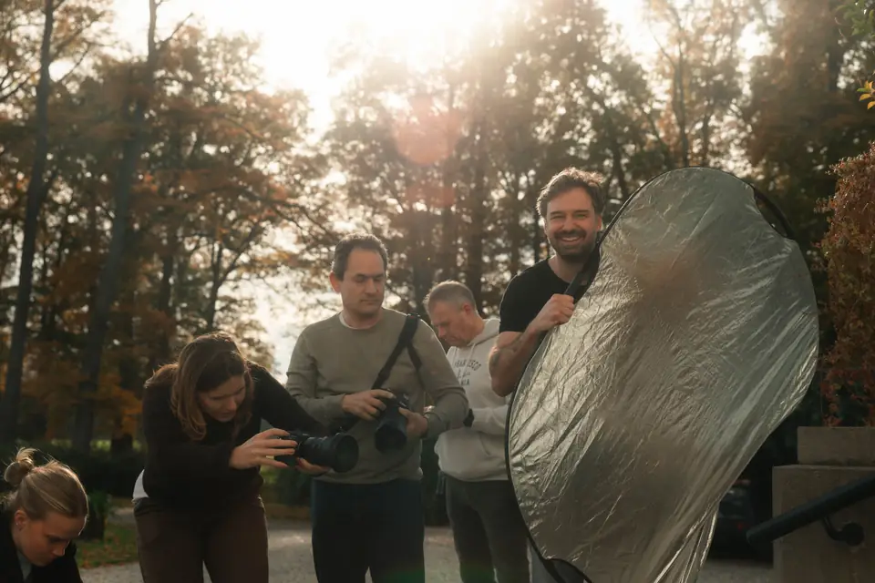 Deelnemers oefenen met camera en reflector tijdens een hybride foto- en videoworkshop op Landgoed Sandenburg
